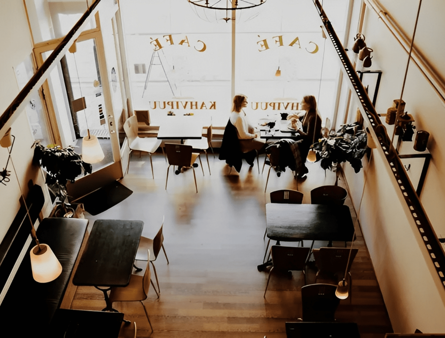 Cozy cafe interior with wooden floors and seating.