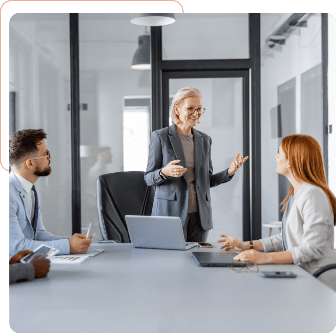 Three colleagues discussing in a modern office meeting room.